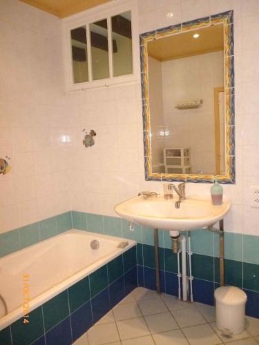 a bathroom with a sink and a tub and a mirror at Gîte robale in Romagne