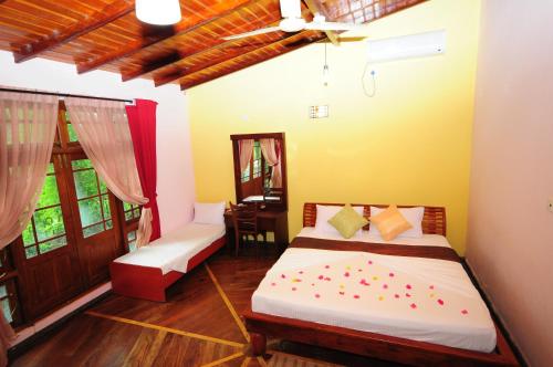 a bedroom with a bed and a desk in it at Hotel Sobana Lake front in Udawalawe