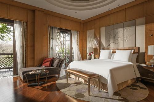 a bedroom with a large bed and a couch at Four Seasons Hotel Hangzhou at West Lake in Hangzhou
