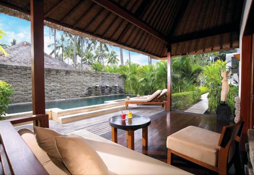 an outdoor living room with a view of a pool at Qunci Villas Resort in Senggigi 