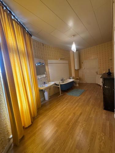 a large room with yellow curtains and a bathroom at Château de Busset in Busset