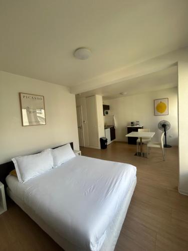 a bedroom with a large white bed and a desk at Apparteo Strasbourg in Strasbourg