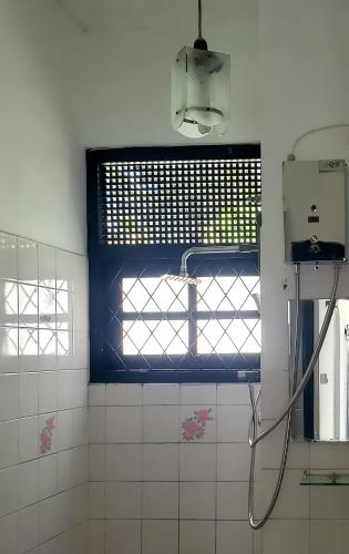 a bathroom with a window and a shower in it at The Colombo House in Battaramulla