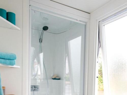 a white room with a mirror and a window at camping les pêcheurs in Pont-de-Poitte