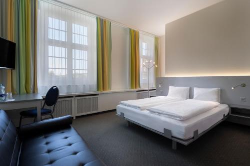 a bedroom with a bed and a desk and a chair at Hotel & Gasthaus Die Perle in Perlen