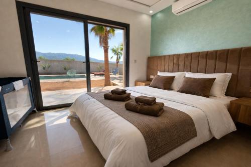 a bedroom with a large bed with two towels on it at Villa Bonheur - Piscine sans vis-à-vis in Berkane