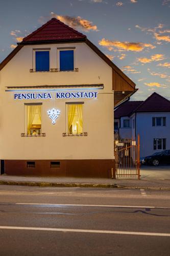 a building with a sign on the side of a street at Pensiunea Kronstadt in Braşov