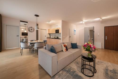 a living room and kitchen with a couch and a table at Baltic Waves Resort by PI Apartments - Official Operator in Międzyzdroje
