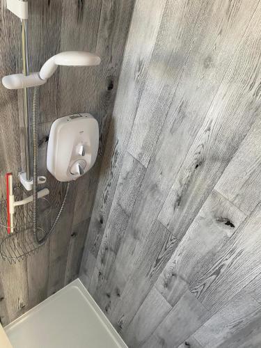 a bathroom with a white toilet and a wooden wall at Yew Trees Barn in Backwell