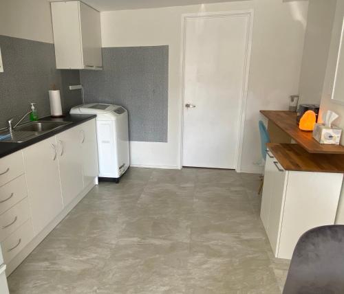 a kitchen with a sink and a refrigerator at 2 Bedroom Unit in Howick in Auckland