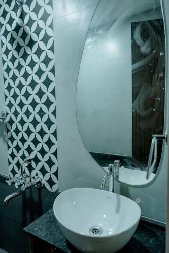 a bathroom with a white sink and a mirror at Arthanaa Villa in Mysore