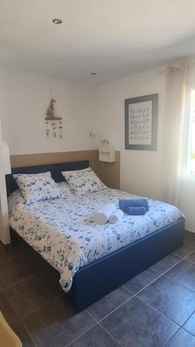 a bedroom with a bed with a blue comforter at Les lauriers fleuris in Méounes-lès-Montrieux