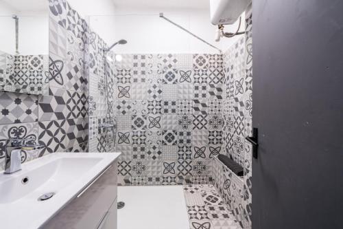 a white bathroom with a sink and a shower at L’Escapade Nîmoise - grand studio centre Nîmes in Nîmes