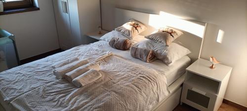 a white bed with pillows on it in a bedroom at Múzsa Apartman in Siófok