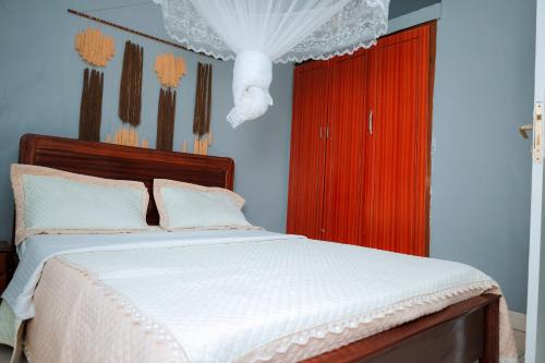 a bedroom with a bed and a red cabinet at Inkindi House in Kigali