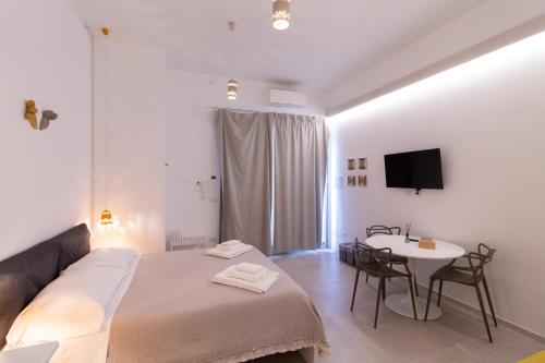 a bedroom with a bed and a table and a tv at Idumea Rooms in Lecce