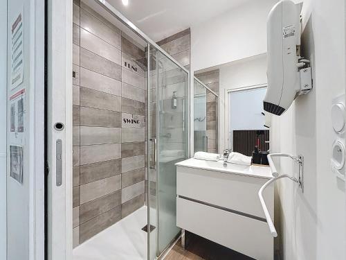 a bathroom with a sink and a shower at Tour d'Auvergne - Appartements en plein centre ville, proche de la cathédrale et de la place de Jaude in Clermont-Ferrand