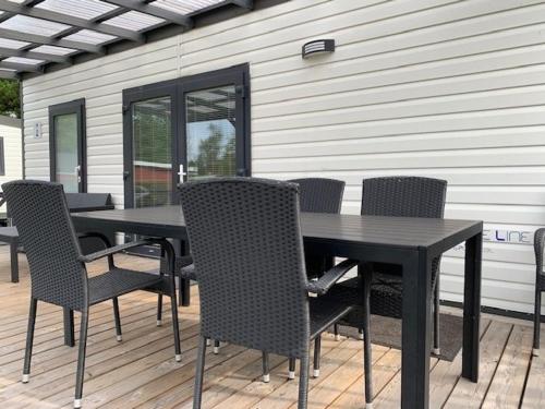 a black table and chairs on a deck at Løgballe Camping & Cottages in Stouby
