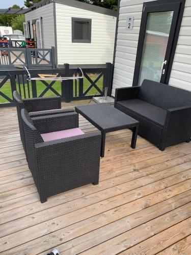 a patio with two chairs and a couch and a table at Løgballe Camping & Cottages in Stouby