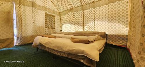 a bedroom with a bed in a room with curtains at Jispa Journey Camp Lahoul & Spiti in Manāli