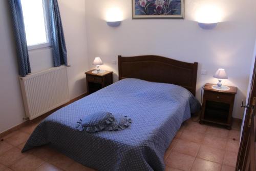 - une chambre avec un lit bleu et 2 tables de nuit dans l'établissement Ferme de Sejour Rebuffel, à La Roque-Esclapon