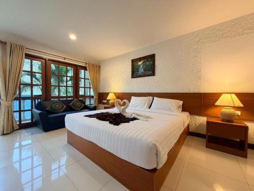 a bedroom with a large bed and a couch at Blue Neptuna Hotel Patong in Patong Beach