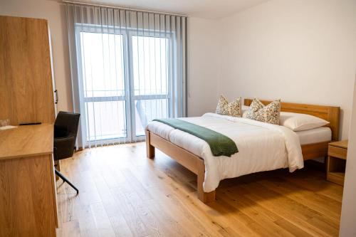 a bedroom with a bed and a large window at Penzión Slnečná in Lendak