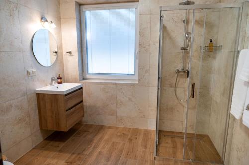 a bathroom with a shower and a sink and a mirror at Penzión Slnečná in Lendak