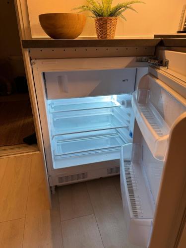 an empty refrigerator with its door open in a kitchen at Cozy Apartment in Nørresundby