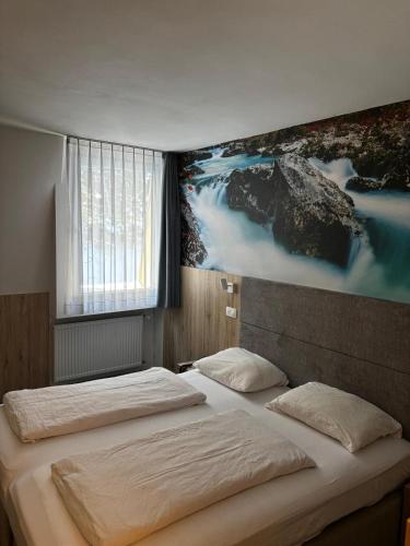 a bedroom with two beds and a painting on the wall at Hotel Alpina in Kranjska Gora