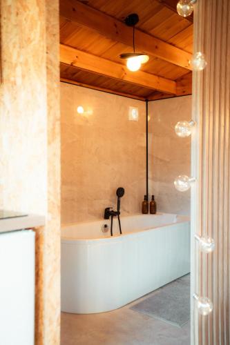 a bath tub in a room with a wooden ceiling at Deux Chalets face à la vallée in Chalezeule