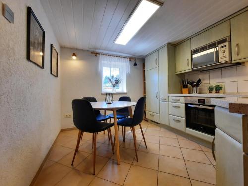 a kitchen with a table and chairs in a room at Ferienhaus am Erzgebirgskamm in Marienberg