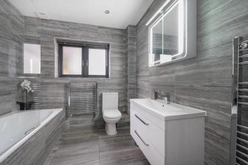 a bathroom with a toilet and a tub and a sink at Large modern self contained apartment in Lymington in Lymington
