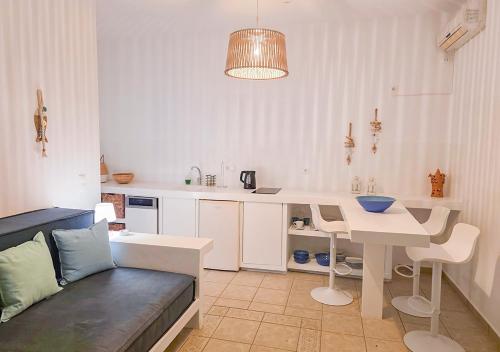 a kitchen with a table and a couch in a room at Panostria Apartments Sifnos in Sifnos