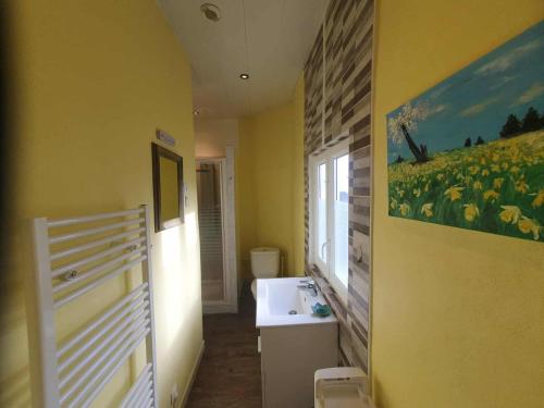 a bathroom with a sink and a painting on the wall at La Tulipe Périgourdine in Le Buisson de Cadouin