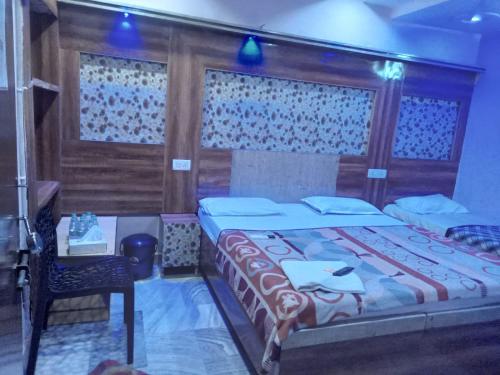 a bedroom with a bed and a table and a chair at hotel shree krishna vaishnav in Agra