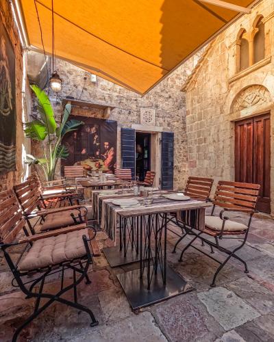 a patio with tables and chairs in a building at Boutique Hotel Hippocampus in Kotor