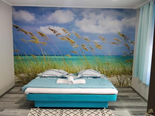 a bed in a room with a mural of a beach at Casa Katiușa in Jurilovca