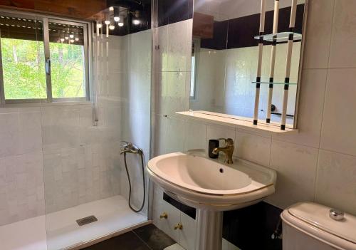 a white bathroom with a sink and a shower at La Mermellina, 22 in Arriondas