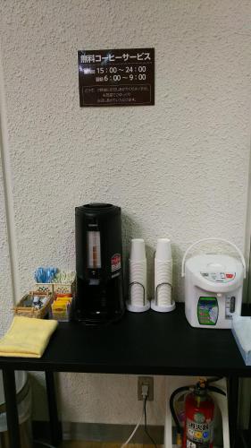a counter with a coffee maker and cups on it at New Central Hotel Katsuta in Hitachinaka