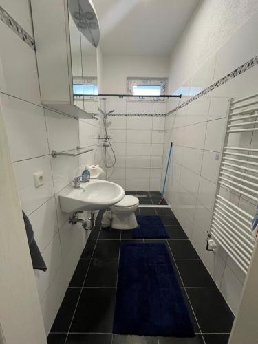 a white bathroom with a sink and a toilet at Monteurswohnung Hamm in Hamm