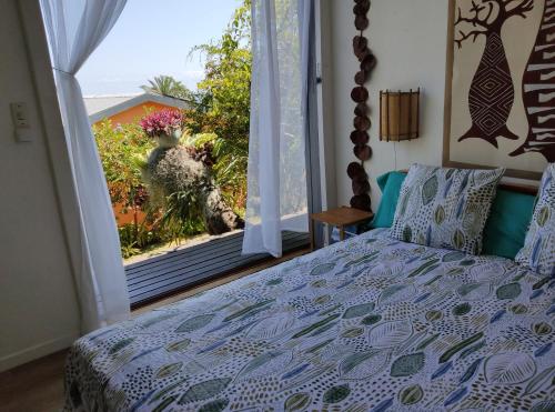 a bedroom with a bed and a window with a view at Chez Evelyne et Thierry in Saint-Leu