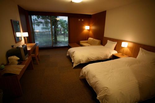 En eller flere senger på et rom på Shiki Resort Prego Hayama