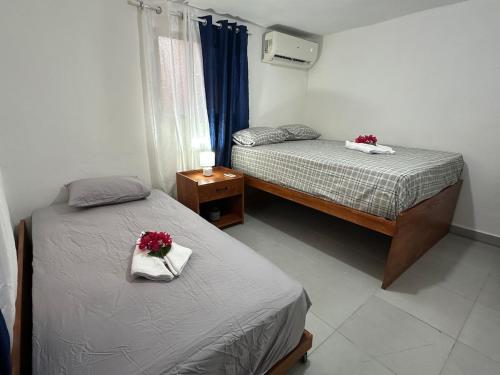 two beds in a bedroom with flowers on them at Brise Dorée de Punta Rucia in Punta Rucia