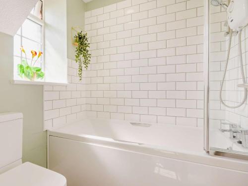 a white bathroom with a tub and a toilet at 2 Bed in Bideford oc-60428 in Westward Ho