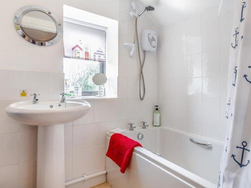 a bathroom with a sink and a tub and a mirror at 3 Bed in Lifton oc-tcoah in Broadwoodwidger