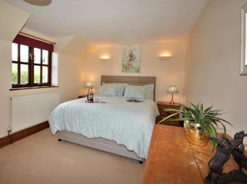 a bedroom with a large bed and a table at 4 Bed in Tiverton oc-60110 in Uplowman