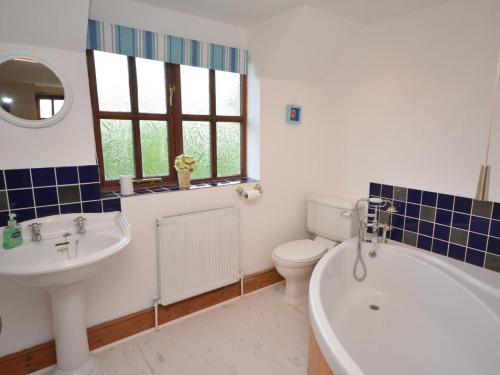 a bathroom with a tub and a toilet and a sink at 4 Bed in Tiverton oc-60110 in Uplowman