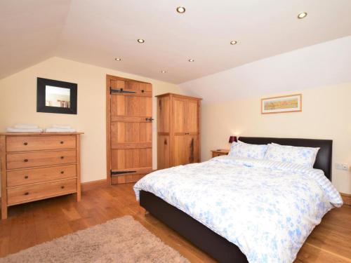 a bedroom with a large bed and a wooden dresser at 2 Bed in Minehead oc-41218 in Timberscombe
