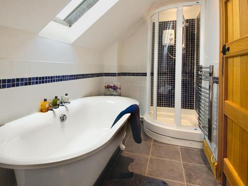 a white bath tub in a bathroom with a window at 2 Bed in Minehead oc-41218 in Timberscombe